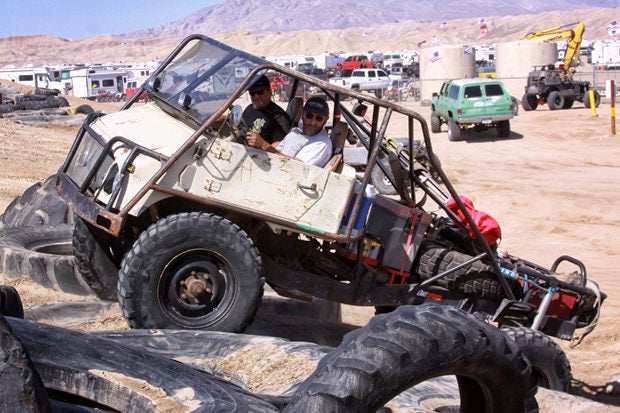 Modified Unimog crawling over massive earth mover tires at Ocotillo Wells SVRA - Truckhaven 4x4 Training Area.