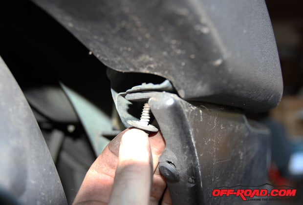 The bumper is held in place with a few clips that just requires some careful pulling, but be sure to remove these tucked-away screws on each side of the front bumper.