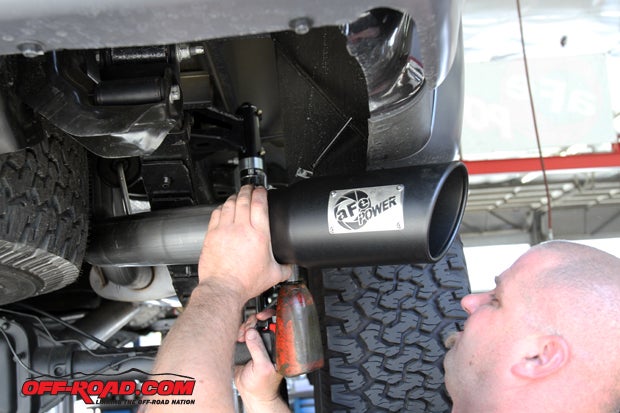 SoCal SuperTrucks technician Ryan Poe secures the final piece of the aFe exhaust in the wrinkle-black SS Exhaust Tip.